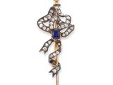 a close up of a broochle with a pearl and a flower