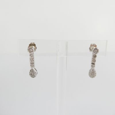 pair of diamond earrings on display on clear acrylic stand