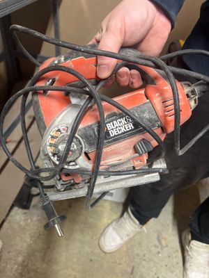 une personne tenant une scie circulaire à la main