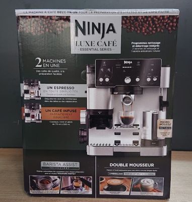 deux cartons contenant des machines à café posés sur une table en bois
