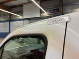 a white car parked in a garage with a sign on the side of the car