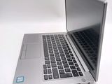 a silver laptop with a blue sticker on it