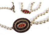 necklace and earrings with pearls on a white surface with a white background
