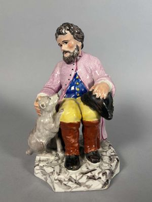 une figurine représentant un homme assis sur un banc avec un chien