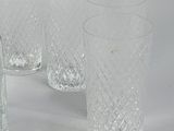 three clear glass vases sitting next to each other on a white surface