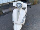 un scooter blanc garé devant un immeuble