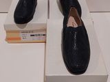 Deux paires de chaussures noires sont posées sur une boîte.