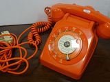 an orange telephone sitting on a table next to a charger