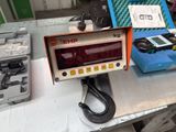 a digital meter on a table next to other electronic tools