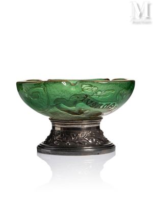 un saladier en verre vert posé sur un support en métal