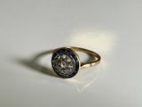 a close up of a gold ring with a coin on it