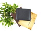a black leather wallet sitting on top of a stack of books