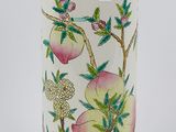 un vase blanc orné d'un motif représentant des fruits