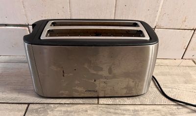 une photo d'un grille-pain posé sur un sol carrelé