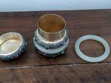a silver cup and a ring sitting on a wooden table