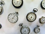 many different types of pocket watches displayed on the wall