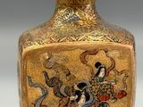a gold vase with a picture of a woman riding a horse