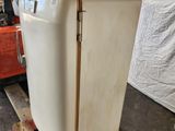 a white refrigerator sitting on a pallet in a warehouse