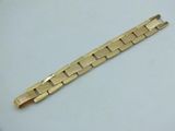 a close up of a gold bracelet on a white surface