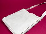 a white handbag on a pink background