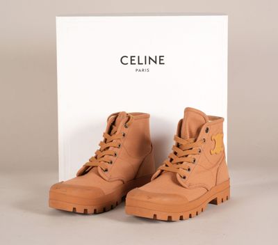 une paire de bottes marron posée sur une boîte blanche