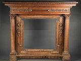 an antique carved wood fireplace surround with a marble top