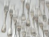 a group of silverware forks and spoons on a white surface