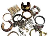 un tas de bagues et de bracelets de toutes sortes posés sur une surface blanche