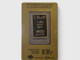 un lingot d'or dans son emballage, sur fond blanc