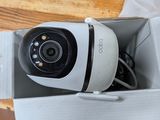 a white camera sitting in a box on a wooden table