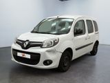 La camionnette blanche est garée dans une grande pièce au sol noir.
