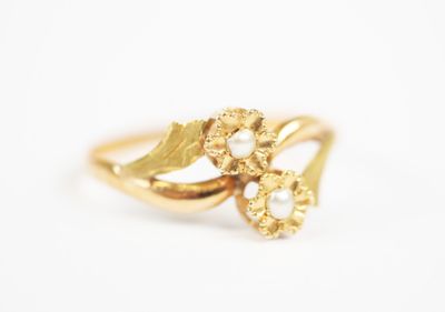 a close up of a gold ring with pearls on it