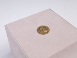 a small box with a gold coin inside of it
