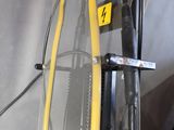 a gym machine with a yellow handlebar in the middle of the room