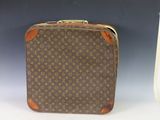 an old louis vuitton suitcase sitting on top of a white table