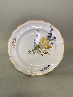 une assiette blanche décorée de fleurs jaunes et bleues