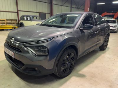 un SUV gris garé dans un garage, avec d'autres voitures en arrière-plan