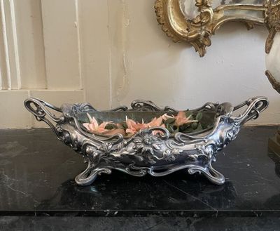 un bol en argent contenant des fleurs, posé sur une table