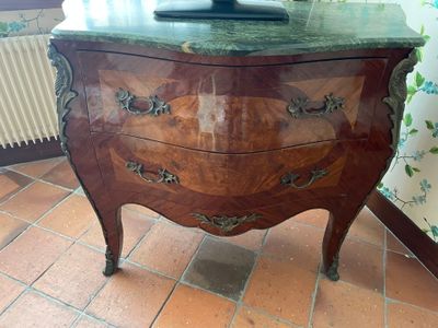 a marble top chest of drawers on a tiled floor
