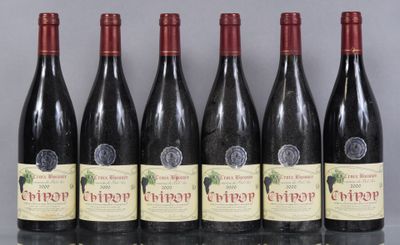 six bouteilles de vin sont alignées sur une table