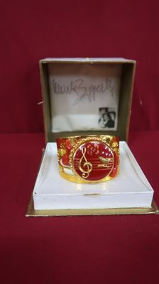 an image of a red and gold ring in a box