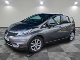 une Nissan Versa grise garée sur un sol à damier dans un garage