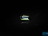 a green tourmaline gems on a black surface