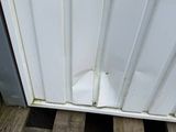 a cat that is sitting on a pallet outside of a door