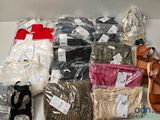 de nombreuses paires de chaussures et des sacs remplis de vêtements sur une étagère