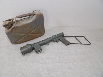 un vieux pistolet et une bombe aérosol posés sur une surface blanche