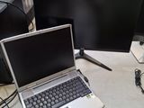 un ordinateur portable posé sur un bureau à côté d'un moniteur