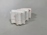 four white egg cartons sitting on top of a white table