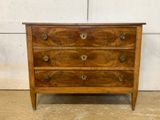 an old wooden chest of drawers with brass hardware on top of it