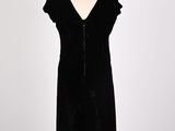 a black dress on a mannequin stand with a white background